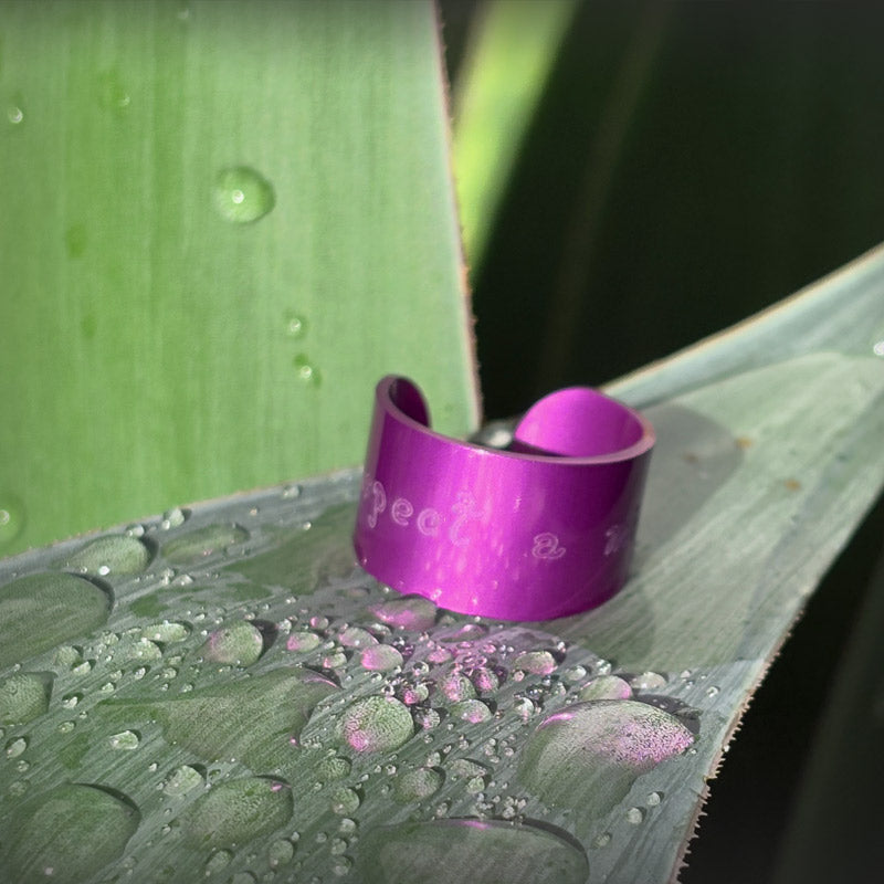 Purple ring with text on a wet green leaf