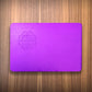 Wallet size purple energy plate on wood surface