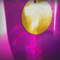 Gold circular object with engravings on a purple background