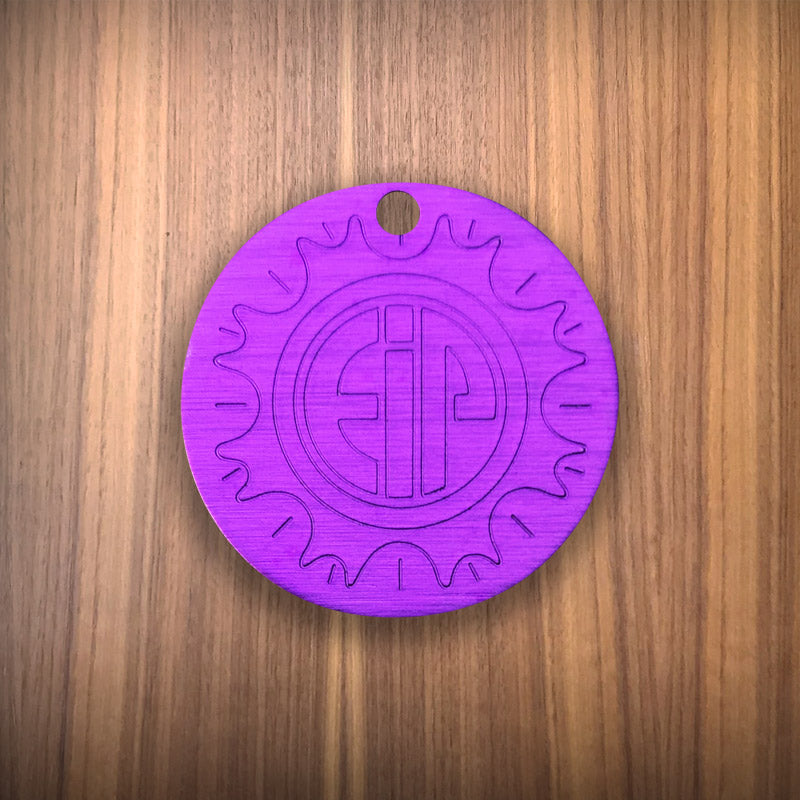 Small Tesla purple disc with stamp logo authentic on wood surface